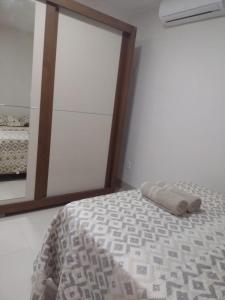 a bed in a room with a mirror and a bed sidx sidx sidx at Lindo apto praia do bessa in João Pessoa
