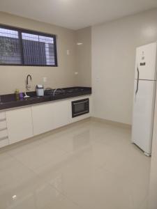 a kitchen with white cabinets and a white refrigerator at Lindo apto praia do bessa in João Pessoa