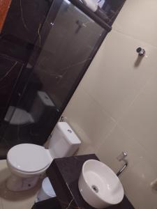 a bathroom with a white toilet and a sink at Lindo apto praia do bessa in João Pessoa