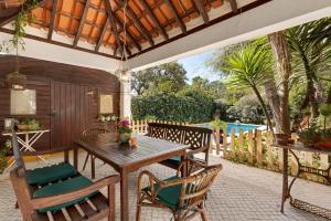 een terras met een houten tafel en stoelen bij Little Paradise 25 min from Lisbon in Azeitao