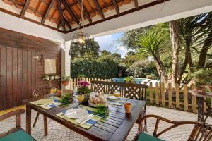 een houten tafel op een terras met een maaltijd erop bij Little Paradise 25 min from Lisbon in Azeitao