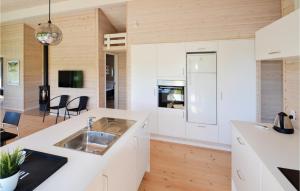 グレーノにあるNice Home In Grenaa With 4 Bedrooms And Wifiの白いキャビネットとシンク付きのキッチン