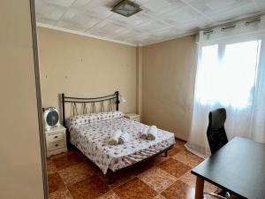 a bedroom with a bed and a table and a window at Bonito apartamento cerca de la playa in Valencia