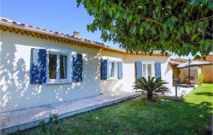 ein Haus mit blauen Fensterläden und einem Hof in der Unterkunft 3 Bedroom Beautiful Home In Montlimar in Montélimar
