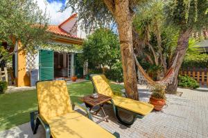 twee stoelen en een tafel en een hangmat in de tuin bij Little Paradise 25 min from Lisbon in Azeitao