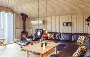 salon z kanapą i piecem opalanym drewnem w obiekcie Lovely Home In Juelsminde With Wifi w mieście Sønderby
