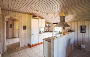kuchnia z białymi urządzeniami i drewnianym sufitem w obiekcie Lovely Home In Juelsminde With Wifi w mieście Sønderby