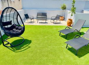 - une balançoire dans une cour avec des chaises et de l'herbe dans l'établissement Yuna Penthouse, 100sqm private rooftop terrasse, Acropolis by foot, à Athènes
