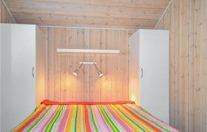 KnebelにあるAwesome Home In Knebel With Sauna And 2 Bedroomsの木製の壁のドミトリールームのベッド1台分です。