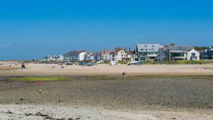 a group of people flying a kite on a beach at Bro Dawel in Rhosneigr