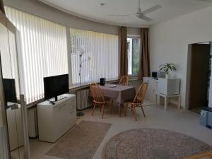 a living room with a table and chairs and a television at Pension Sonnenhof in Braunlage