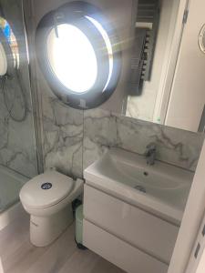 łazienka z toaletą, umywalką i oknem w obiekcie La Mare Houseboat w mieście Nederhorst den Berg