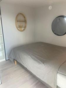 a white bedroom with a bed and a mirror at La Mare Houseboat in Nederhorst den Berg