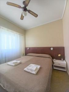1 dormitorio con 1 cama y 2 toallas blancas en Hotel América en Mar del Plata