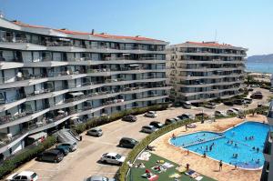 een groot appartementencomplex met een zwembad naast een parkeerplaats bij ROCAMAURA III 2-6 in L'Estartit