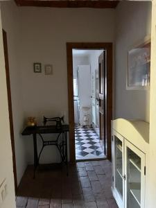 um quarto com uma mesa e um corredor com um frigorífico em La casa del Tiglio em Borgo San Lorenzo