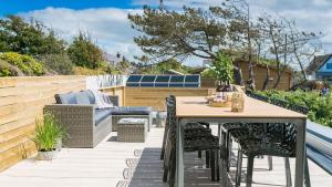 a patio with a wooden table and chairs at Brig y Don in Rhosneigr