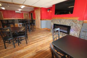 a dining room with red walls and a fireplace at Blackstone Lodge and Suites in Lead