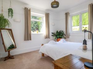 sypialnia z łóżkiem, lustrem i oknami w obiekcie Penang w mieście St Austell