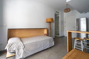 a bedroom with a bed and a table and a stool at Apartamento Calpe Beach in Calpe