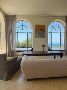a living room with a couch and two windows at The Cliff Hotel. in Tel Aviv