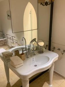 a bathroom with a white sink and a mirror at The Cliff Hotel. in Tel Aviv