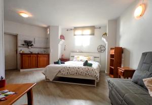 バジェ・グラン・レイにあるPension Candelariaのベッドルーム(ベッド1台、ソファ付)