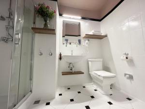 een witte badkamer met een wastafel en een toilet bij Pollera in Krakau