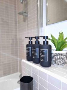 three bottles ofodorizers sitting on a shelf in a bathroom at Charming studio in Bricklane in London