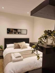 Un dormitorio con una cama y una mesa con una planta en Charming studio in Bricklane en Londres