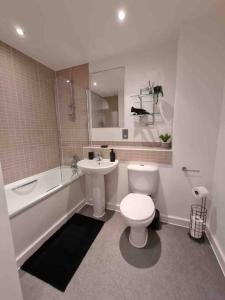 a bathroom with a toilet and a sink and a tub at Charming studio in Bricklane in London