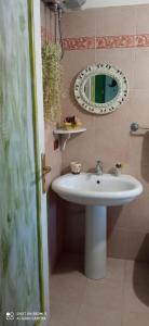 La salle de bains est pourvue d'un lavabo blanc et d'un miroir. dans l'établissement Piccolo Sogno, à Massafra