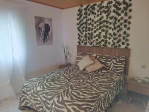 1 cama en un dormitorio con una pared de estampado de cebra en Bonita casa en el bosque - El Tiemblo, en El Tiemblo