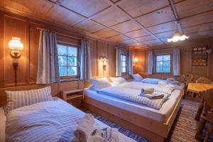 two beds in a room with wooden walls at Ferienhaus Blendolma in Sankt Gallenkirch