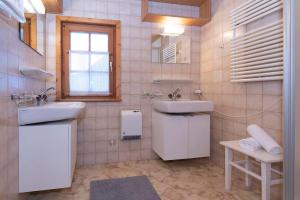 ein weißes Bad mit 2 Waschbecken und einem Fenster in der Unterkunft Ferienhaus Blendolma in Sankt Gallenkirch