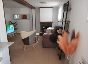 salon z kanapą i telewizorem w obiekcie Bonita casa en el bosque - El Tiemblo w mieście El Tiemblo