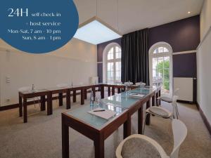 een conferentiezaal met tafels, stoelen en ramen bij Classik Hotel Antonius in Keulen