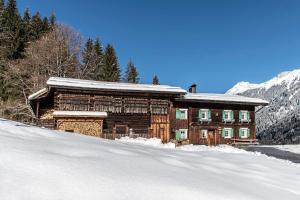 ein Blockhaus im Schnee mit einem schneebedeckten Dach in der Unterkunft Ferienhaus Blendolma in Sankt Gallenkirch