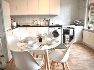 Lovely 2BR Cottage in Stansted في ستانستيد ماونتفيتشت: مطبخ مع طاولة وكراسي في مطبخ