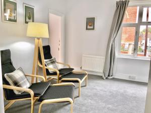 a living room with chairs and a lamp and a window at Charming 2 Bedroom Cottage in Stansted in Stansted Mountfitchet