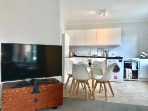 a kitchen with a table and chairs and a television at Lovely 2BR Cottage in Stansted in Stansted Mountfitchet