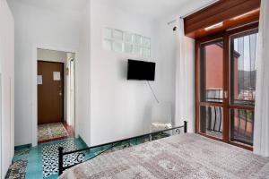 - une chambre avec un lit et une télévision murale dans l'établissement Appartamento Menelao, à Cava deʼ Tirreni