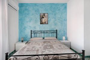 een slaapkamer met een bed met een blauwe muur bij Appartamento Menelao in Cava deʼ Tirreni