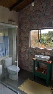 a bathroom with a toilet and a sink and a window at Caiowa Floripa guesthouse in Florianópolis