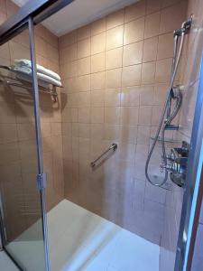 a shower with a glass door in a bathroom at Private Unit at The Camp John Hay Manor in Baguio