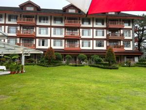 a large building with a lawn in front of it at Private Unit at The Camp John Hay Manor in Baguio