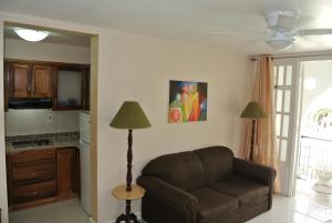 a living room with a couch and a kitchen at Beach One Bedroom Suite 13 in Ocho Rios