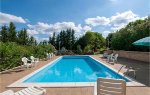 piscina con sedie e ombrellone di Cozy Home In Servigliano With Sauna a Servigliano
