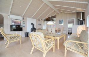 KnebelにあるAwesome Home In Knebel With 3 Bedrooms, Sauna And Wifiのリビングルーム(テーブル、椅子、テレビ付)