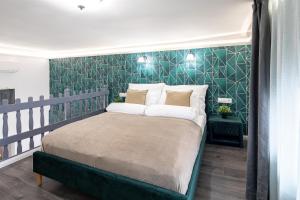 a bedroom with a bed with a green accent wall at Dessewffy Premium Apartment in Budapest